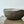 Ceramic bowl on a matching ceramic tray with scalloped edges against a white background