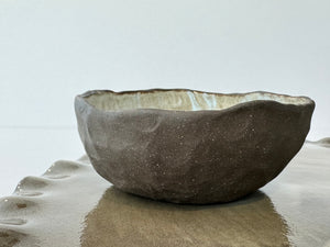 Ceramic bowl on a matching ceramic tray with scalloped edges against a white background