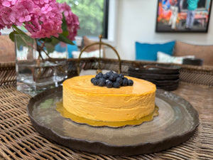 Yellow cake with blueberries on a decorative plate in a home setting